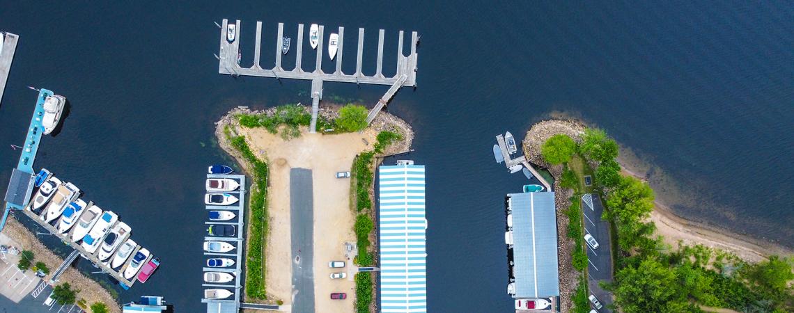 Aerial view of boats slips in a marina on a river.